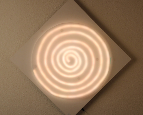 Mandala Lichtkunst – LED-beleuchtete Spirale mit Acrylglas & Holz-Unterbau | Modernes Wandobjekt LED-hinterleuchtetes Mandala auf Holz-Unterbau mit Acrylglas-Abdeckung. Die RGB-Beleuchtung sorgt für anpassbare Farbstimmungen per App oder Fernbedienung. Ideal für Meditationsräume, moderne Innenarchitektur und zeitgenössische Lichtkunst.